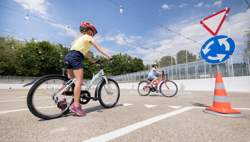 Kinder fahren mit dem Velo auf dem Verkehrspark im Weyermannshaus