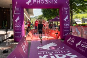 Kind rennt in Zielbereich beim Kids Triathlon, Nicola Spirig empfängt es