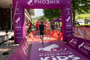 Kind rennt in Zielbereich beim Kids Triathlon, Nicola Spirig empfängt es