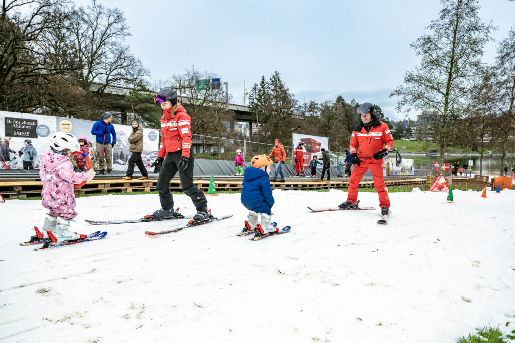 Kinder und Skilehrpersonen auf der Skipiste im Weyermannshaus.