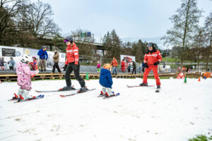 Kinder und Skilehrpersonen auf der Skipiste im Weyermannshaus.