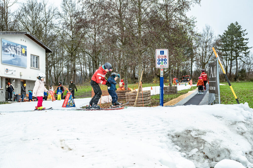 Kinder und Skilehrpersonen auf der Skipiste im Weyermannshaus