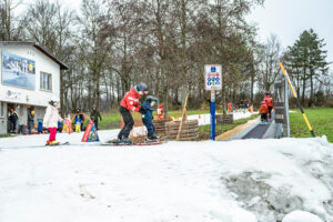 Kinder und Skilehrpersonen auf der Skipiste im Weyermannshaus