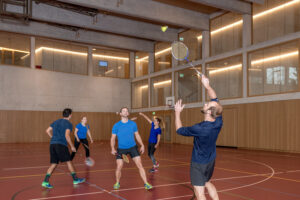 Personen spielen Badminton in einer Turnhalle