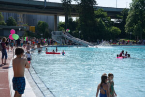 Badegäste im Freibad Weyermannshaus, Rutschbahn im Hintergrund