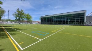 Kunstrasenfeld Gymnasium Neufeld mit Gebäude im Hintergrund