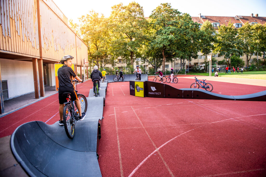 Kinder fahren mit dem Velo auf einem mobilen Pumptrack